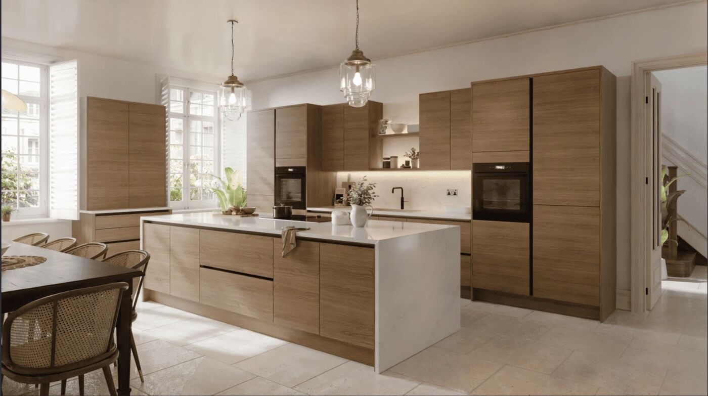 Remodeled kitchen with warm wood cabinetry, a white-topped island, and pendant lights