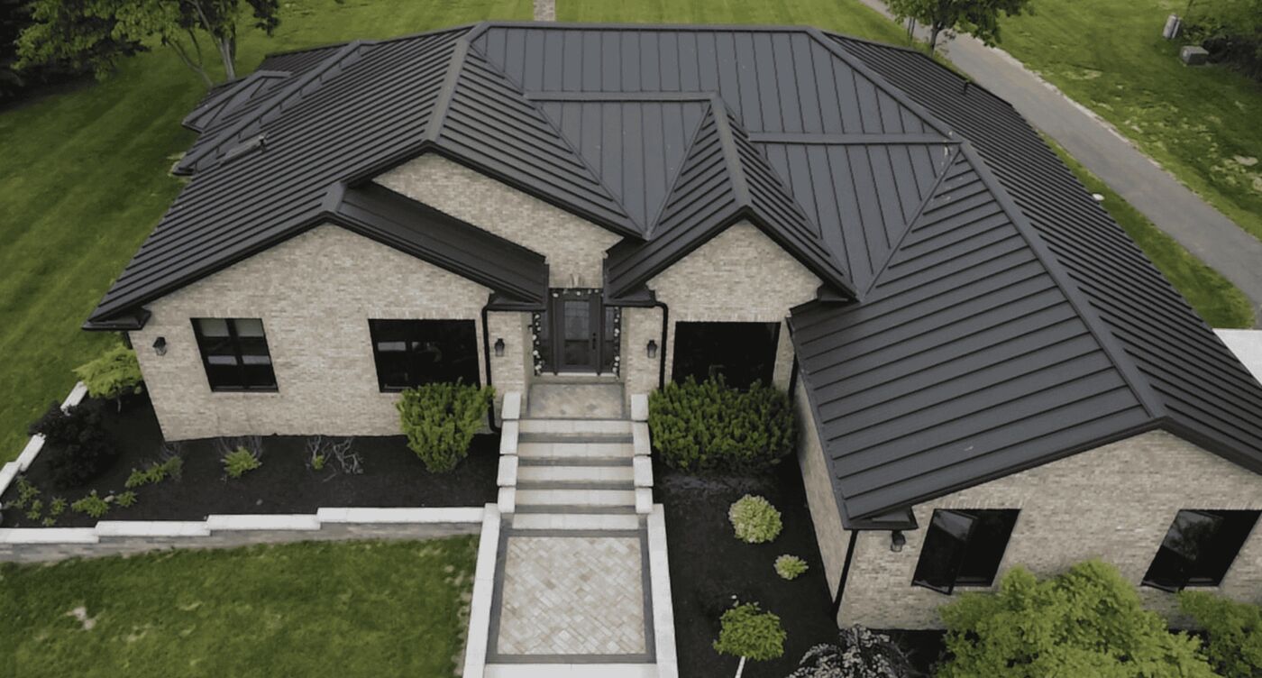 Aerial view of a home with a new dark standing-seam metal roof